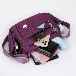 Purple quilted oxford fabric crossbody bag with multiple zipper pockets for storage
