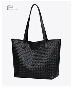 Detailed view of black woven PU leather tote bag showing side profile and handle texture