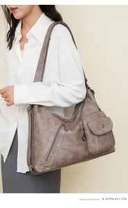 Detail view of taupe vintage crossbody bag with multi-pocket design and aged leather texture