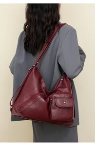 Detail of burgundy crossbody bag with lychee texture and multi-pocket functional design