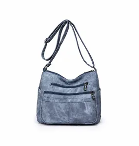 Détail du sac bandoulière vintage bleu avec trois poches avant zippées en métal robuste