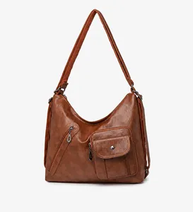 Detail view of brown vintage crossbody bag showing zipper pocket and lychee texture leather