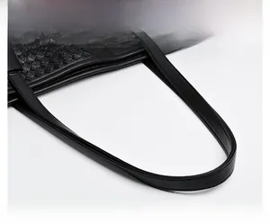 Close-up of the woven leather texture and comfortable top handle on this black tote bag