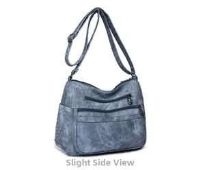 Vue latérale d'un grand sac bandoulière en cuir souple bleu avec fermetures éclair