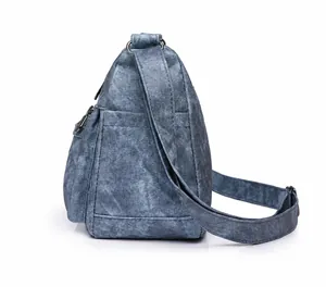 Vue détaillée latérale d'un sac bandoulière en denim bleu avec fermetures éclair