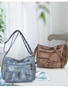 Close-up of vintage soft leather crossbody bags in denim blue and dark brown colors