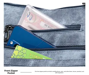 Détail du sac à bandoulière en denim avec doubles poches zippées pour une organisation