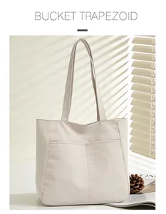 Detailed close-up of a minimalist cream bucket trapezoid tote bag with elegant front stitching