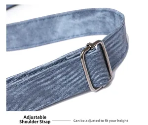 Détail d'une bandoulière réglable en denim bleu avec boucle en métal argenté robuste