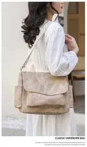 Detail of khaki retro PU shoulder bag with wide geometric patterned strap in outdoor setting