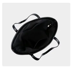 Internal view of a black woven tote bag showing its spacious lining and zip pockets