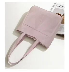 Close-up of pink tote bag with front dual pockets and high-quality nylon fabric