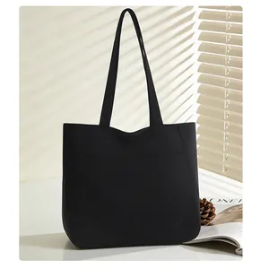 Macro detail of high-capacity black canvas tote bag with reinforced stitching for daily use