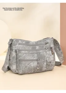 Detail of grey multi-zippered crossbody bag with vintage washed fabric texture