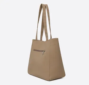 Side view of khaki tote bag showing smooth texture and back zipper pocket detail