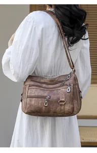 Detail view of vintage brown soft leather crossbody bag with multiple zip compartments