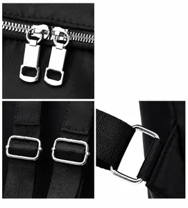 Detailed macro view of polished silver metal zippers and hardware on a black nylon backpack