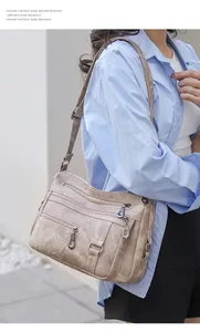 Detail of vintage soft leather crossbody bag with multiple zippers and adjustable strap