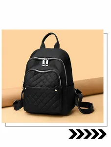 Close-up of black nylon backpack with quilted diamond pattern and silver zippers