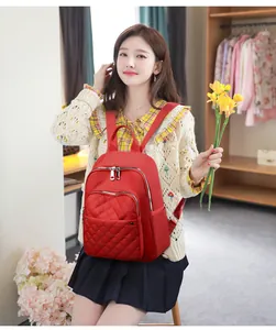 Macro view of red quilted nylon backpack with large front zip pocket and durable straps