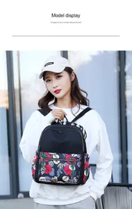 Fashionable black nylon backpack with colorful floral print details shown on model