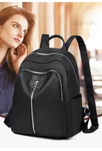 Détail du sac à dos en nylon noir imperméable avec fermetures éclair en métal et poche latérale