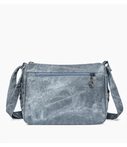 Detail view of the back zipper pocket and washed denim texture of the shoulder bag