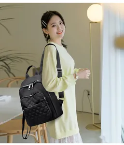 Detail of black nylon backpack with quilted diamond pattern and silver metal zipper