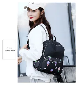 Outdoor model shot of a black backpack with colorful hot air balloon print and metal zippers