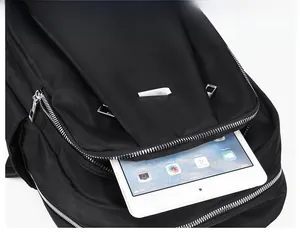 Close-up of black nylon backpack showing large capacity holding a tablet and silver zippers