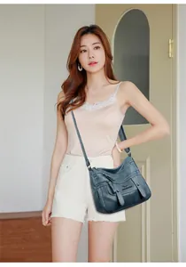 Detailansicht der dunkelgrünen Leder-Umhängetasche mit Multi-Pocket-Design und Gurt