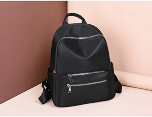 Detail view of large capacity black oxford backpack with dual front zipper pockets