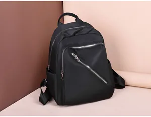 Detail of durable black nylon backpack with three silver zippers and side pockets
