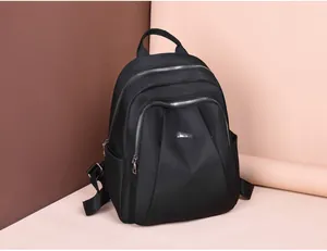 Detail view of black oxford nylon backpack with multiple silver zipper pockets