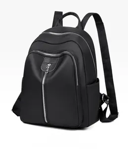 Detail view of durable black oxford cloth backpack with multiple zipper compartments