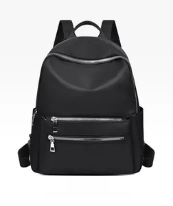 Détail frontal du sac à dos noir en tissu oxford avec plusieurs fermetures éclair