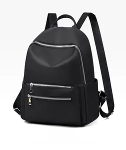 Détail de la texture en tissu Oxford noir et des fermetures éclair argentées du sac