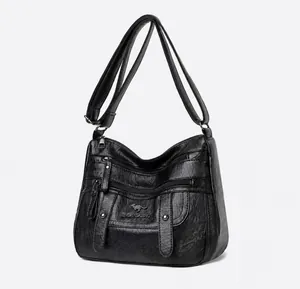 Detailansicht der schwarzen PU-Leder-Schultertasche mit mehreren funktionalen Metallreißverschlüssen