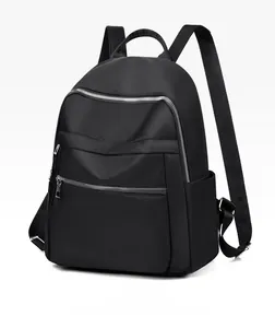 Vue détaillée du sac à dos en nylon noir avec fermetures éclair argentées et poches