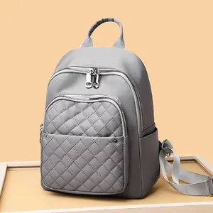 Waterproof grey nylon backpack with quilted front pocket and large capacity for women