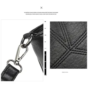 Detail of black textured leather bag with silver metal buckle and decorative stitching