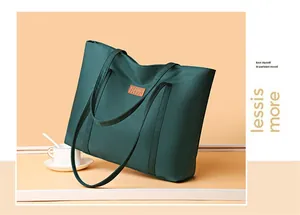Detail of dark green tote bag with leather logo patch and minimalist fabric texture