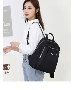 Detailed view of black nylon travel backpack with silver zippers and multi-layer storage