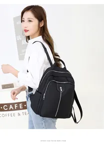 Détail d'un sac à dos noir en nylon avec poches zippées et bretelles en tissu résistant