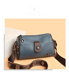 Close-up of leather crossbody bag with lychee texture and woven floral shoulder strap