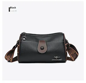 Detailed view of black litchi grain leather crossbody bag with brown trim and woven strap