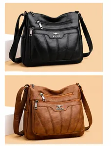 Detalle de bolsos bandolera negros y marrones con múltiples cremalleras y costuras en V