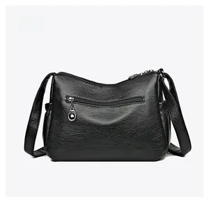 Back view of black faux leather crossbody bag showing functional zipper pocket and side pockets