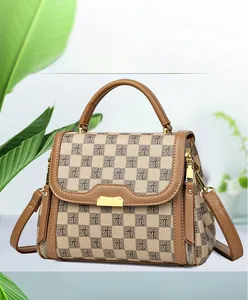 Detail of beige and brown textured handbag with gold hardware and logo pattern