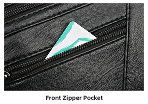 Detailed close-up of a front zipper patch pocket on a black pebble leather handbag
